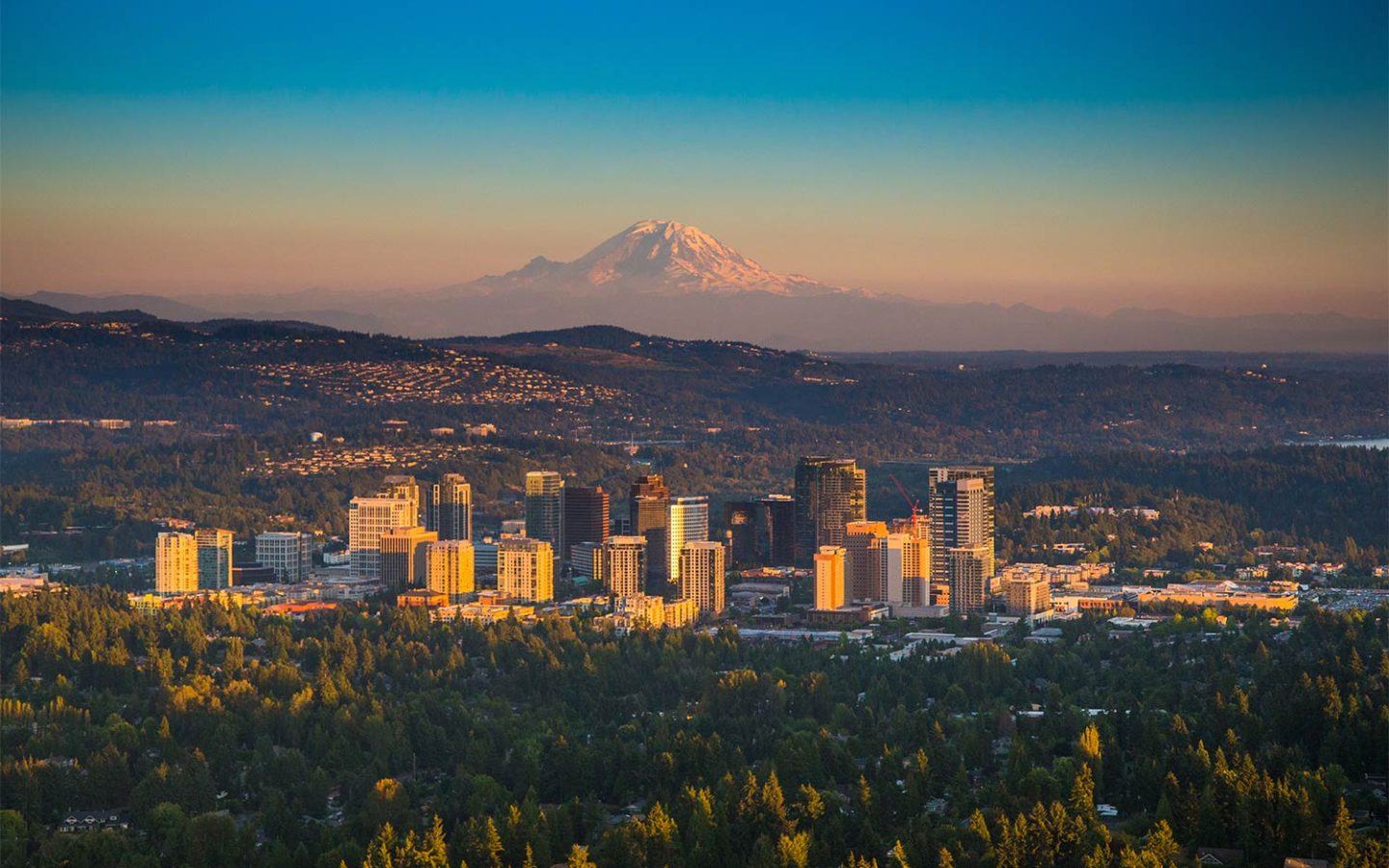 cityscape with large mountains in the back through the horizon